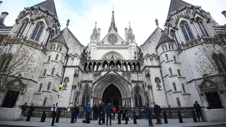 Members of the press wait outside the Royal Courts of Justice, in central London