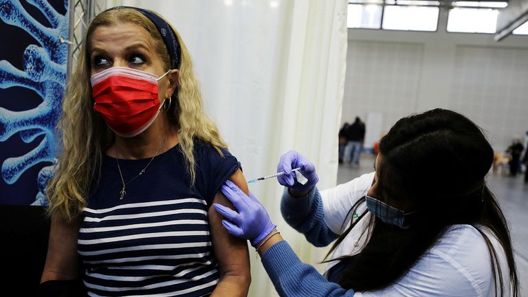 PHOTO DE DOSSIER: Une femme reçoit une vaccination contre la maladie à coronavirus (COVID-19) dans un centre temporaire de l'organisation de maintenance des soins de santé Clalit (HMO), sur un terrain de basket à Petah Tikva, Israël, le 28 janvier 2021. REUTERS / Ammar Awad / File Photo