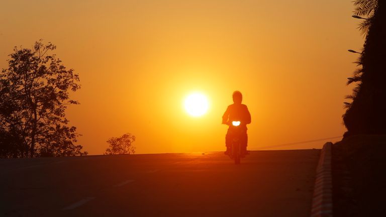 A man rides his motorbike during sunset in Naypyitaw, Myanmar. Pic: AP