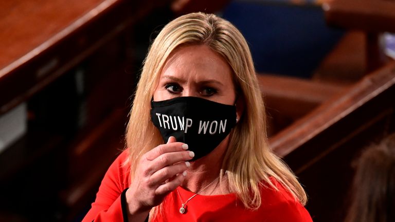 FILE - In this Sunday, Jan. 3, 2021, file photo, Rep. Marjorie Taylor Greene, R-Ga., wears a "Trump Won" face mask as she arrives on the floor of the House to take her oath of office on opening day of the 117th Congress at the U.S. Capitol in Washington. President Joe Biden&#39;s inauguration has sown a mixture of anger, confusion and disappointment among believers in the baseless QAnon conspiracy theory. Greene, who has expressed support for the conspiracy theories, called for Biden’s impeachment a