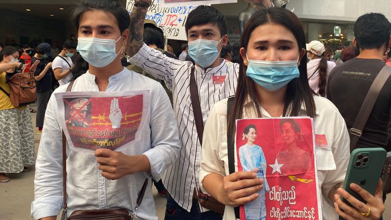Protestors hold up photos of the de-facto Myanmar leader Aung San Suu Kyi.