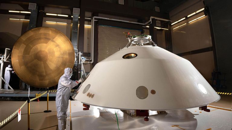 Задняя часть космического корабля Mars 2020 (на переднем плане) и тепловой экран (на заднем плане) были оснащены MEDLI2, набором датчиков для измерения окружающей среды и характеристик космического корабля во время его турбулентного спуска на Марс.  Предоставлено: НАСА / Лаборатория реактивного движения-Калтех.