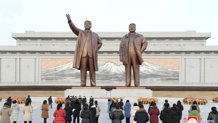 Flowers are laid in front of the bronze statues of Kim Il Sung and his son Kim Jong Il on the Day of the Shining Star, the birth anniversary of Kim Jong Il