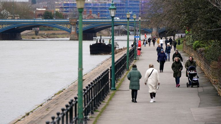 Pedestrians walk beside the River Trent in West Bridgeford, Nottingham

