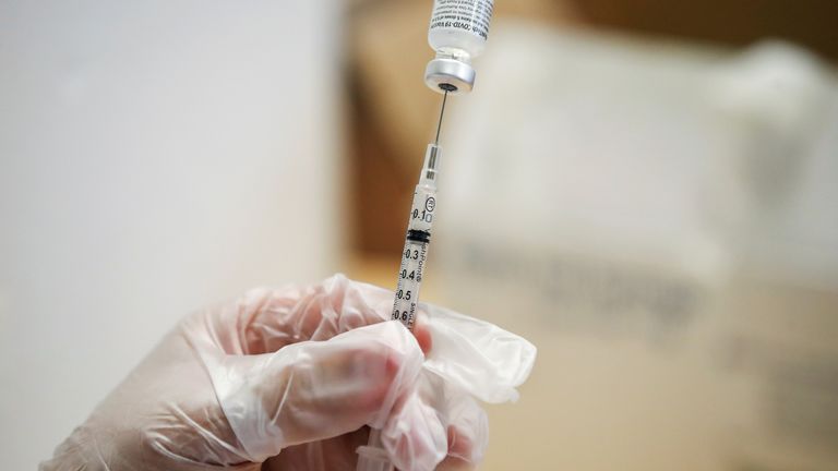 A healthcare professional prepares a dose of the Pfizer-BioNTec vaccine