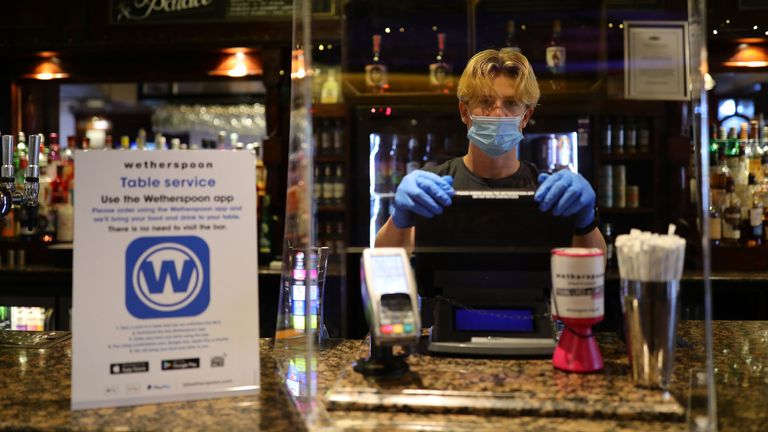 A staff member at the reopening of Wetherspoons&#39; Toll Gate pub, in Hornsey, London