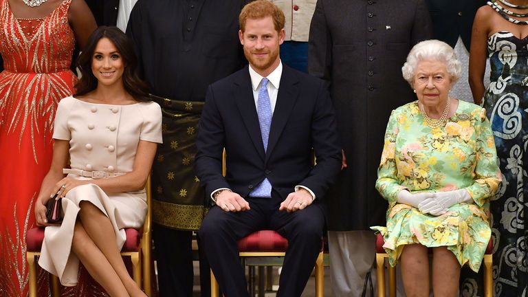 Queen Elizabeth, Prince Harry and Meghan, the Duchess of Sussex pose for a picture with some of Queen&#39;s Young Leaders at a Buckingham Palace reception following the final Queen&#39;s Young Leaders Awards Ceremony 2018