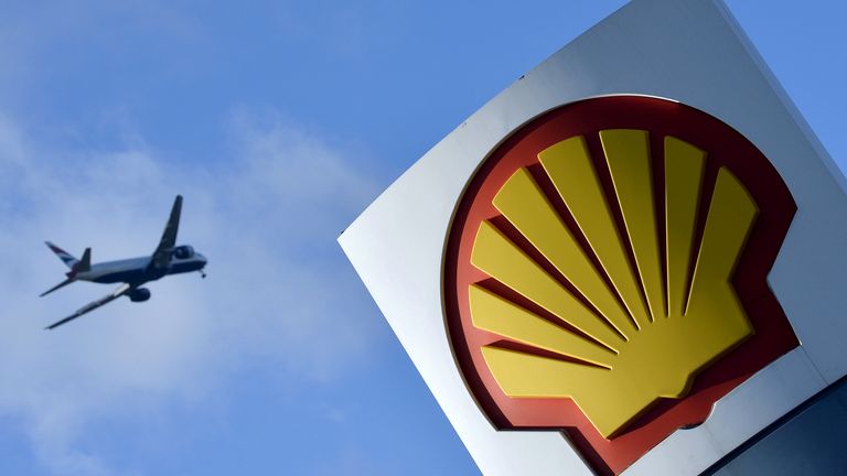 A passenger plane flies over a Shell logo at a petrol station in west London, January 29, 2015. REUTERS/
