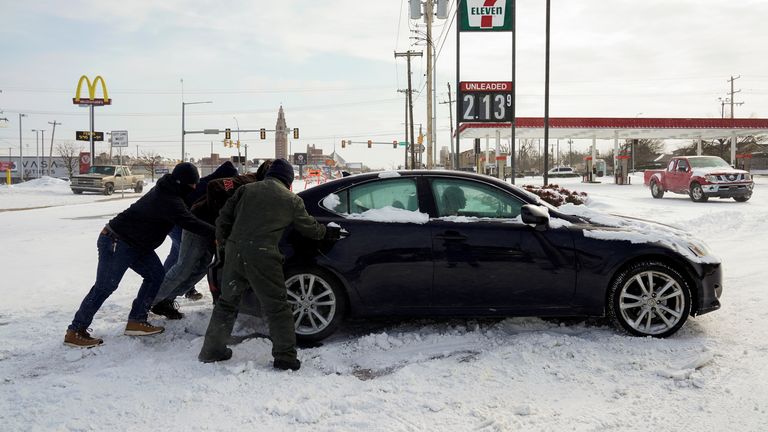 People in Oklahome try to free a stuck motorist during record-breaking freezing weather.
