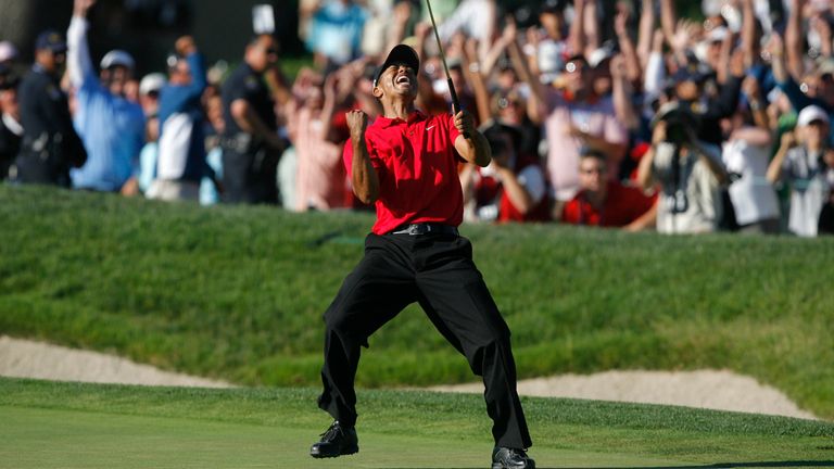 Tiger Woods celebrates after making a birdie on the 18th hole