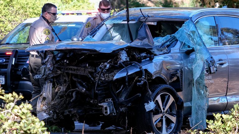 Police officers look over the damaged car. Pic: AP
