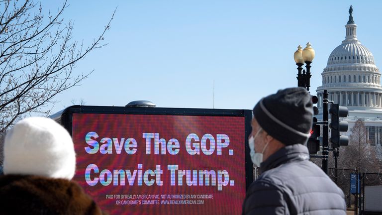 UNITED STATES - February 8: People look at a truck displaying a sign that reads "Save The GOP. Convict Trump" near the Capitol grounds in Washington on Monday, Feb. 8, 2021. The Senate Impeachment trial of former President Donald Trump begins tomorrow after he was charged with "incitement of insurrection" after his supporters stormed the Capitol in an attempt to overturn November&#39;s election result. (Photo by Caroline Brehman/CQ Roll Call via AP Images)