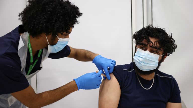 A person gets the coronavirus vaccine, at a vaccination centre in Westfield Stratford City shopping centre, amid the outbreak of coronavirus disease (COVID-19), in London, Britain, February 18, 2021. REUTERS/Henry Nicholls