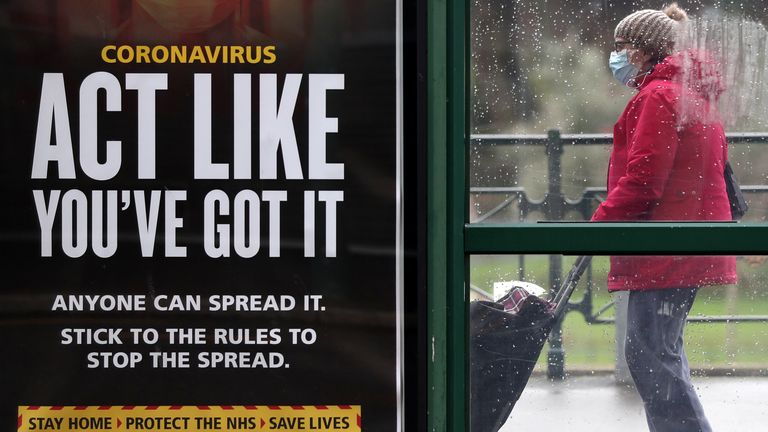A person makes their way past an &#39;Act like you&#39;ve got it&#39; government coronavirus sign at a bus stop in Bournemouth, Dorset, during England&#39;s third national lockdown to curb the spread of coronavirus. Picture date: Tuesday February 16, 2021.