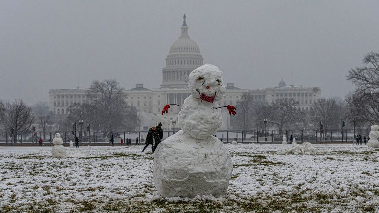 A snowman is seen against the US Capitol in Washington DC