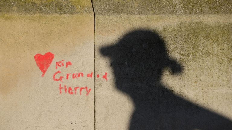 People are silhouetted against the COVID-19 Memorial Wall on the Embankment, central London, which has been painted with hearts in memory of the more than 145,000 people who have died in the UK from coronavirus. Picture date: Monday March 29, 2021.