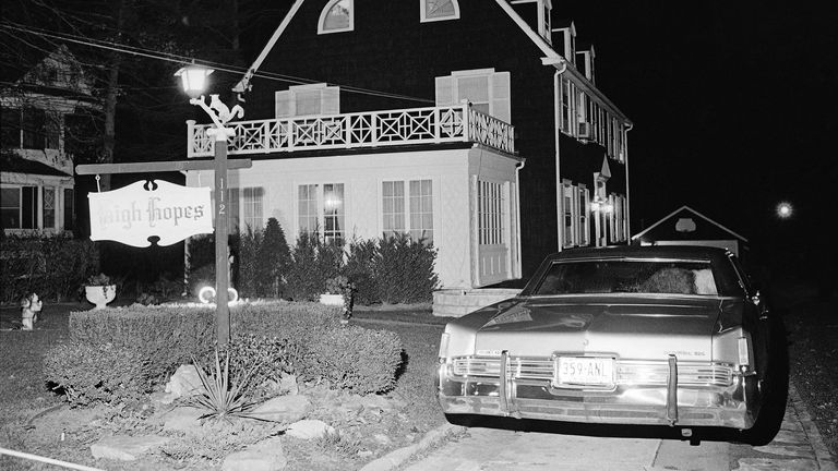 Police and members of the Suffolk County Coroner's Office investigate the murder of six people found shot in Amityville, N.Y., Nov. 14, 1974. The six bodies were from the Ronald DeFeo family and were discovered by another member of the family at early Wednesday evening. (AP Photo/Richard Drew)