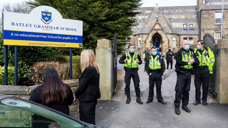Police positioned outside the school gates. Angry parents are protesting outside a Batley Grammar School, West Yorks, after a teacher allegedly showed derogatory caricatures of the Prophet Muhammad, pictured in West Yorks, March 25 2021.  See SWNS story SWLEprotest.