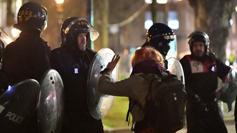 A protester confront s police officers during Tuesday night&#39;s demonstration