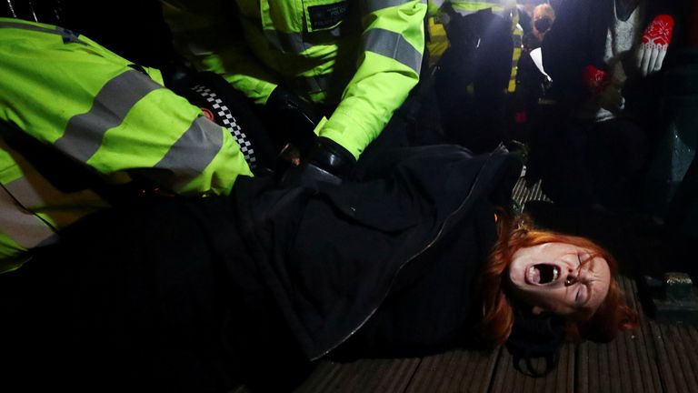 Police detain a woman as people gather at a memorial site in Clapham Common Bandstand, following the kidnap and murder of Sarah Everard, in London, Britain March 13, 2021. REUTERS/Hannah McKay TPX IMAGES OF THE DAY