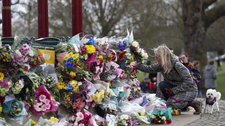 Les gens laissent des fleurs sur le stand du groupe à Clapham Common, à Londres, après l'annulation officielle de la veillée Reclaim These Streets pour Sarah Everard.  L'agent de police en service Wayne Couzens, 48 ​​ans, a été accusé vendredi soir d'enlèvement et de meurtre du responsable du marketing, qui a disparu alors qu'il rentrait chez un ami dans le sud de Londres le 3 mars. Date de la photo: samedi 13 mars 2021 .