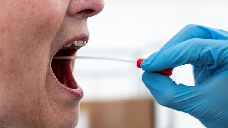 A medical worker performs a mouth swab on a patient to test for the coronavirus disease (COVID-19) in a new tent extension of Danish National Hospital Rigshospitalet in Copenhagen, Denmark April 2, 2020