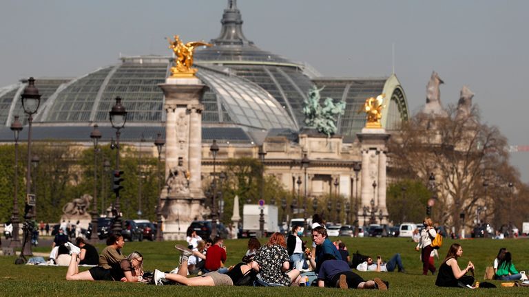 People sitting outside on the grass in Paris