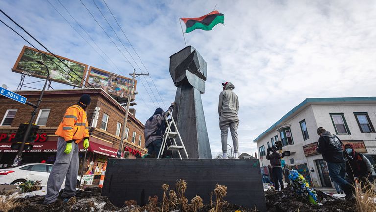 Des artistes et des membres de la communauté aident à ériger une nouvelle statue de poing sur la place où l'homme noir George Floyd est mort
