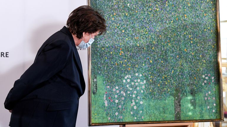 French Culture Minister Roselyne Bachelot stands next to the painting "Rosebushes under the Trees" by Austrian painter Gustav Klimt