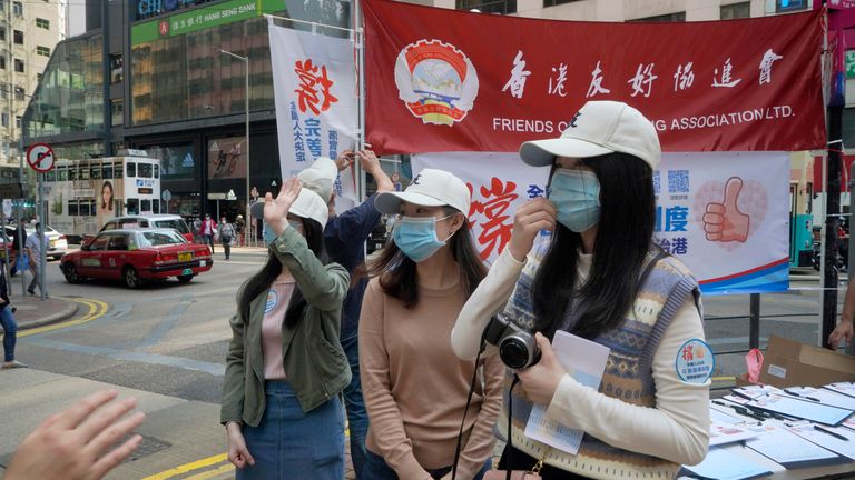 Pro-China staff members collect signatures supporting changes to election rules in Hong Kong