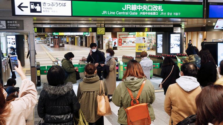 People in Sendai gather in front of a ticket gate at a station as train services are suspended. Pic: AP