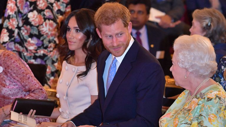 La reine Elizabeth de Grande-Bretagne, le prince Harry et Meghan, la duchesse de Sussex posent pour une photo avec certains des jeunes leaders de la reine lors d'une réception au palais de Buckingham après la dernière cérémonie de remise des prix des jeunes leaders de la reine, en Londres