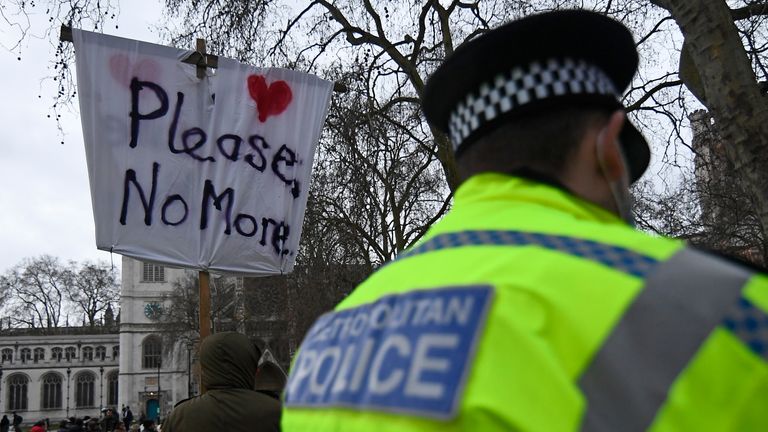 A police officer looks on as demonstrators gather during a protest in Parliament Square in London, Sunday, March 14, 2021. London&#39;s Metropolitan Police force was under heavy pressure Sunday to explain its actions during a vigil for Sarah Everard whom one of the force&#39;s own officers is accused of murdering. (AP Photo/Alberto Pezzali)