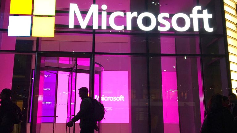 In this Nov. 10, 2016, photo, people walk near a Microsoft office in New York. Microsoft Corp. reports quarterly financial results on Thursday, Jan. 26, 2017. (AP Photo/Swayne B. Hall)