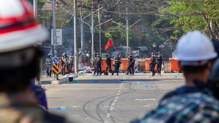 Police are seen in front of a protester barricade in Yangon