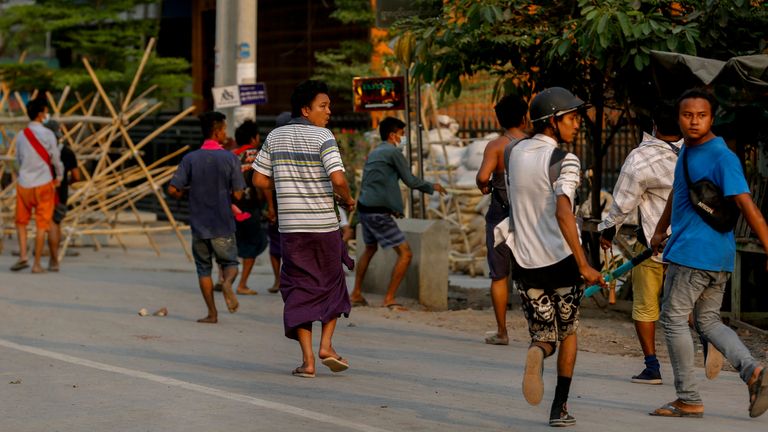 Anti-coup protesters run from riot policemen and soldiers in Mandalay