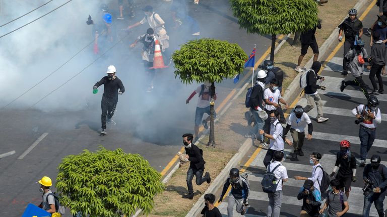 Demonstrators flee from teargas canisters during a protest against the military coup in Yangon