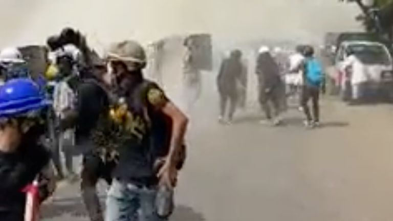 Protesters run away from tear gas in Mandalay