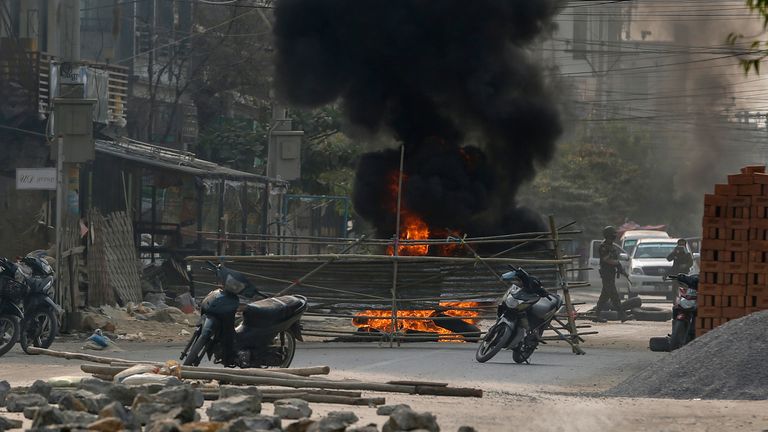 Armed riot policemen and soldiers reach a makeshift barricade made by anti-coup protesters in Mandalay. Pic: AP