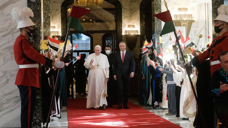 Iraqi Prime Minister Mustafa Al-Kadhimi walks with Pope Francis upon his arrival at Baghdad International Airport