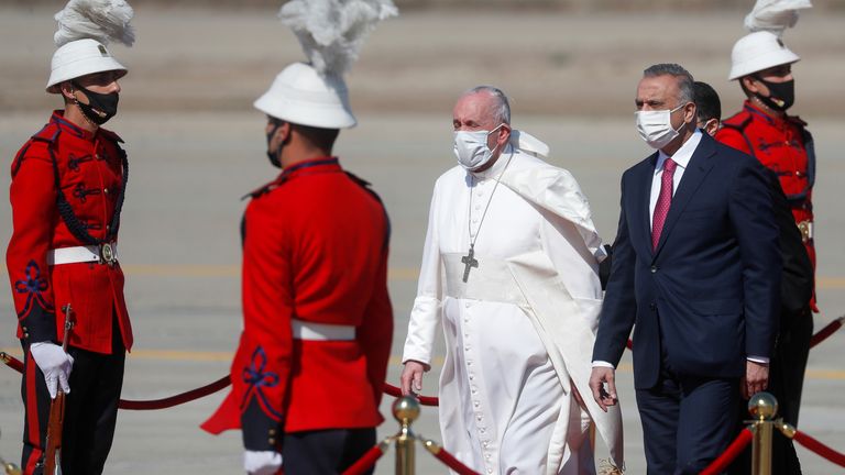 Pope Francis is received by Iraqi Prime Minister Mustafa Al-Kadhimi upon disembarking from his plane at Baghdad International Airport to start his historic tour in Baghdad, Iraq, March 5, 2021. REUTERS/Yara Nardi