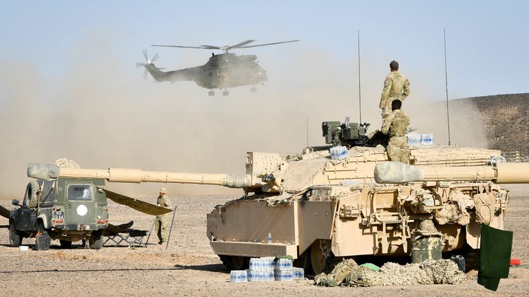 A Puma takes off behind a Challenger II Main Battle Tank in the Oman desert, where UK forces are taking part in a month-long exercise, Saif Sareea 3.