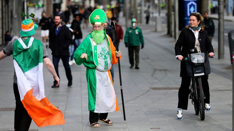 A man dressed as St Patrick walks down O...Connell street  in Dublin, Ireland, Wednesday, March, 17, 2021. St Patrick...s Day celebrations have been cancelled for the second year in a row due to the covid-19 crisis.   (AP Photo/Peter Morrison)