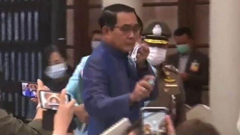 Thai Prime Minister Prayut Chan-o-cha sprays a row of journalists with an aerosol