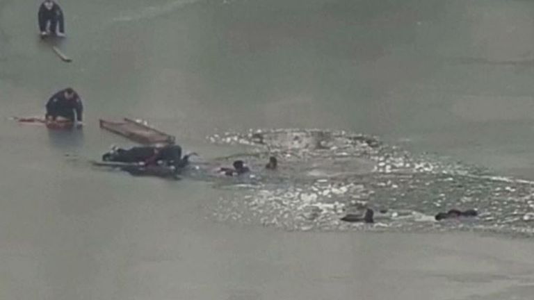 Police officers rescue three man and a teenager from an icy lake