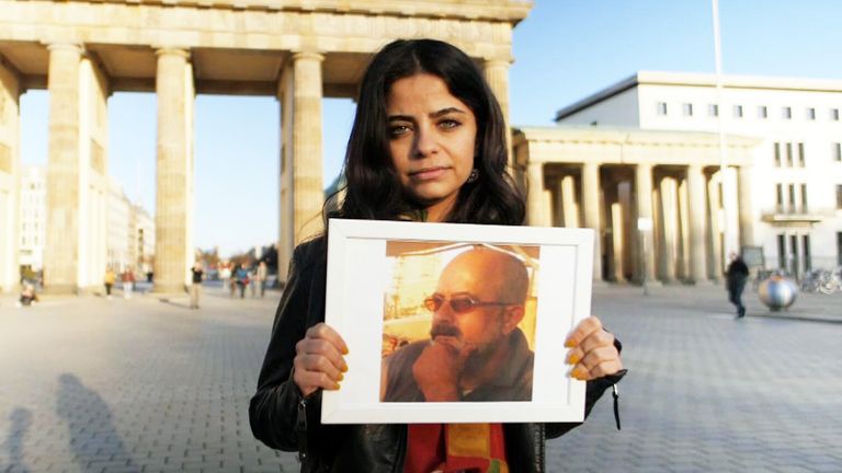 Wafa Mustafa holds a picture of her father Ali, who was seized in 2013