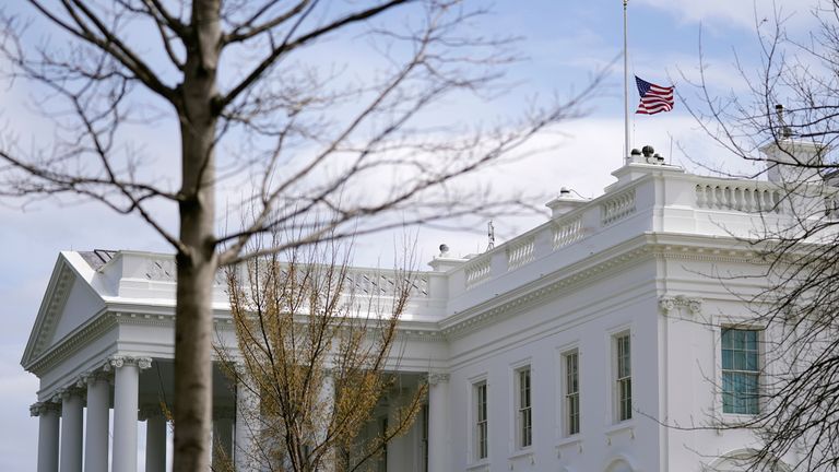 An American flag flies at half-staff above the White House in Washington, Tuesday, March 23, 2021. (AP Photo/Patrick Semansky)