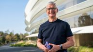 Apple CEO Tim Cook holds an iPhone 12 in a new purple finish 