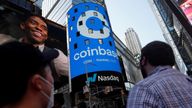 People watch as the logo for Coinbase Global Inc, the biggest U.S. cryptocurrency exchange, is displayed on the Nasdaq MarketSite jumbotron at Times Square in New York