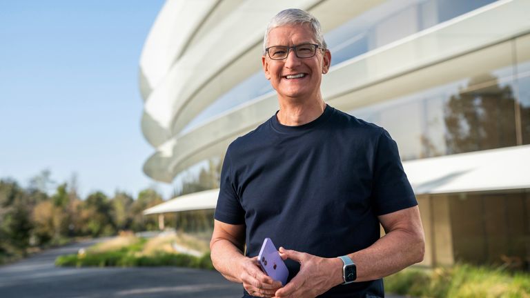 Apple CEO Tim Cook holds an iPhone 12 in a new purple finish
